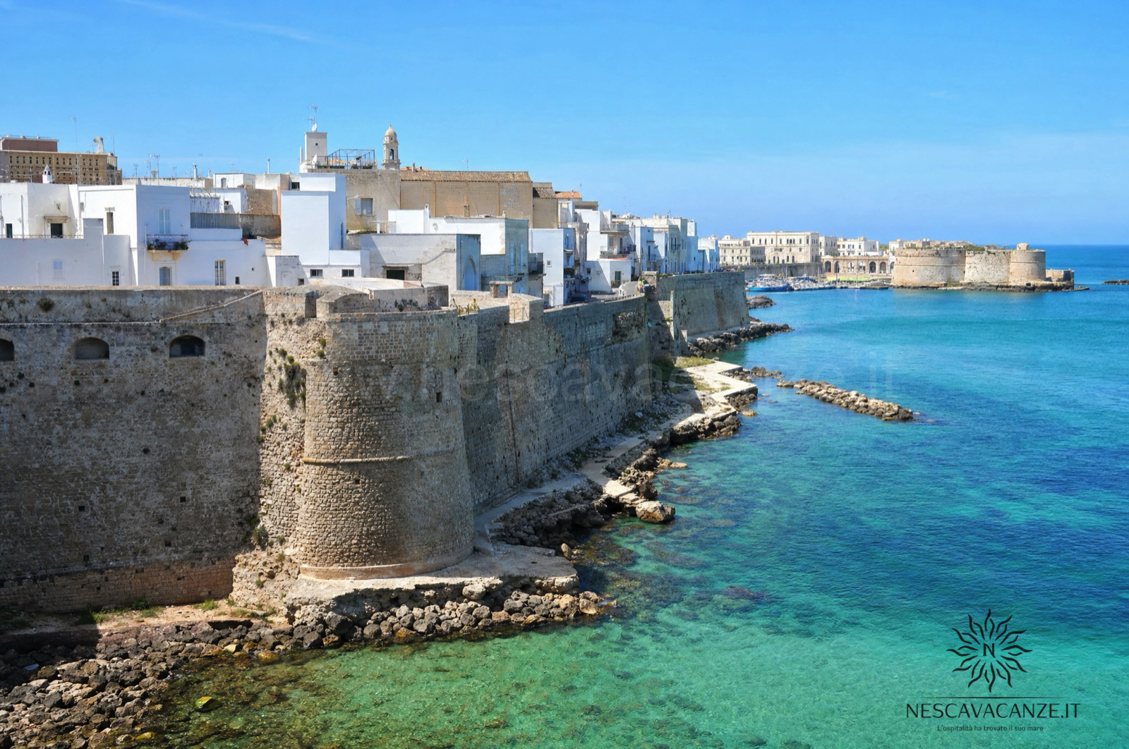 Il borgo bianco di Otranto con il castello aragonese affacciato sul mare turchese, nel Salento