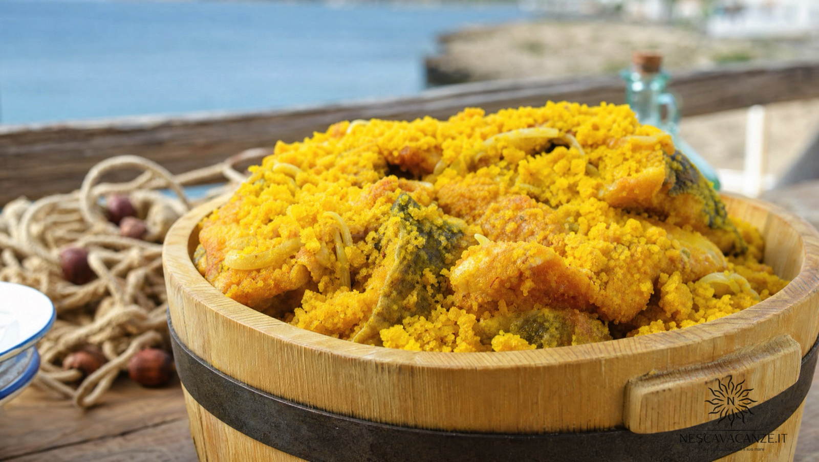 Scapece gallipolina, pesce fritto e marinato in pangrattato giallo zafferano, servito in un mastello di legno in riva al mare a Gallipoli