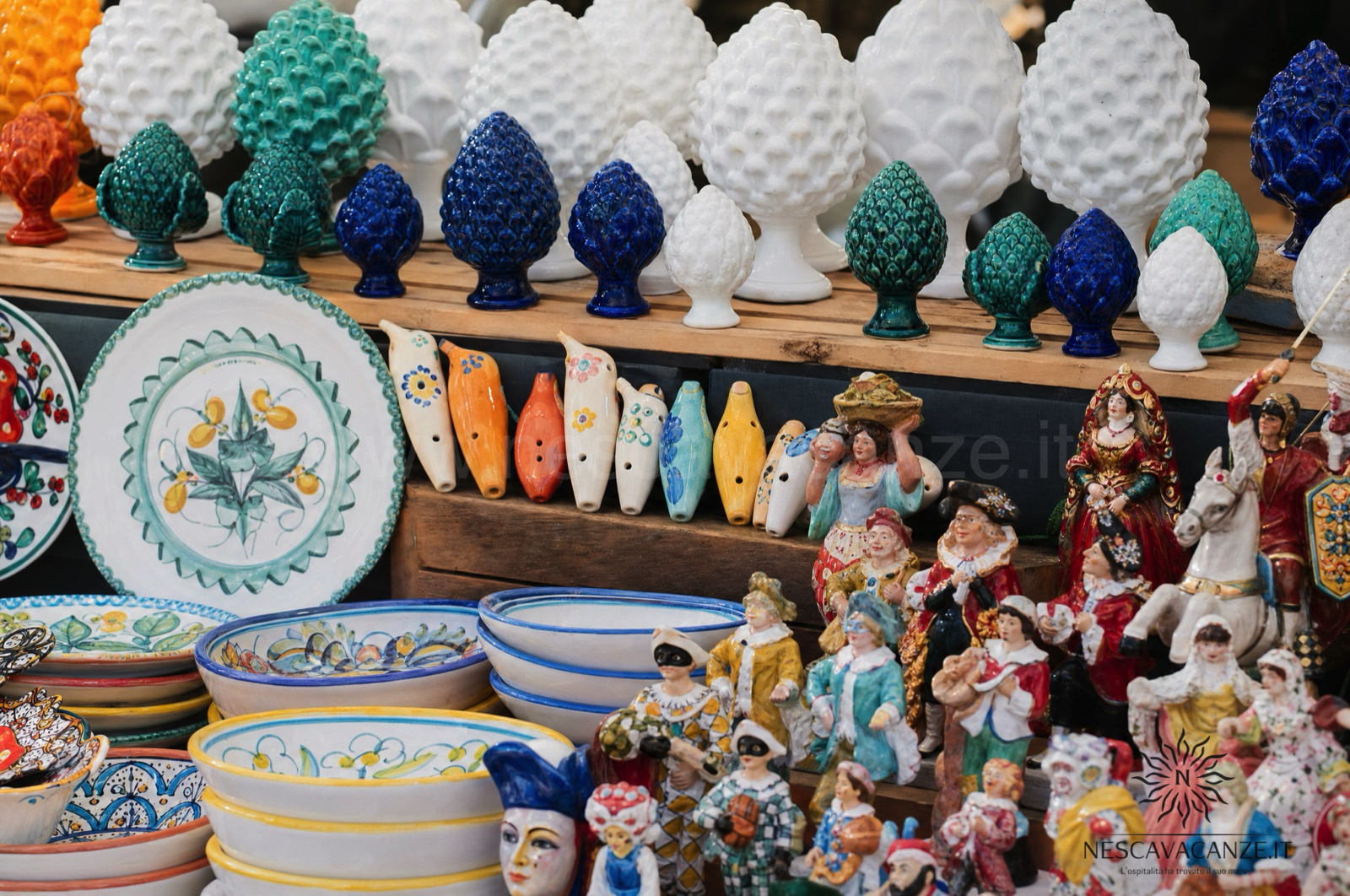 Banco di artigianato salentino con ceramiche di Grottaglie e figure in cartapesta leccese a un mercatino del Salento
