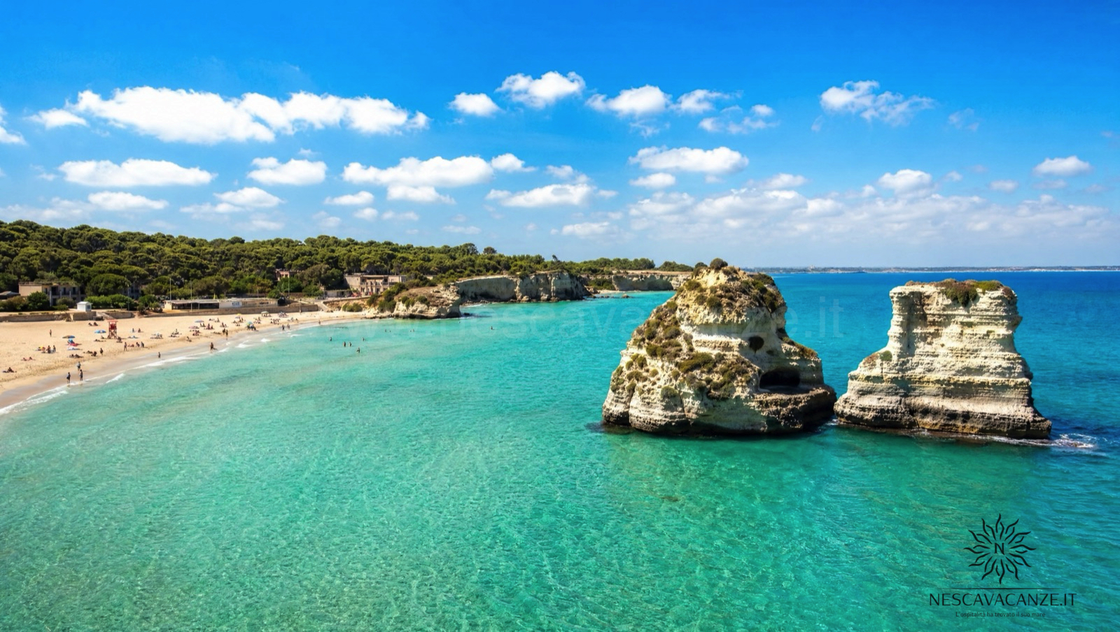 La baia di Torre dell'Orso con i due faraglioni delle Due Sorelle che emergono dal mare turchese, la mezzaluna di sabbia dorata e la pineta sullo sfondo